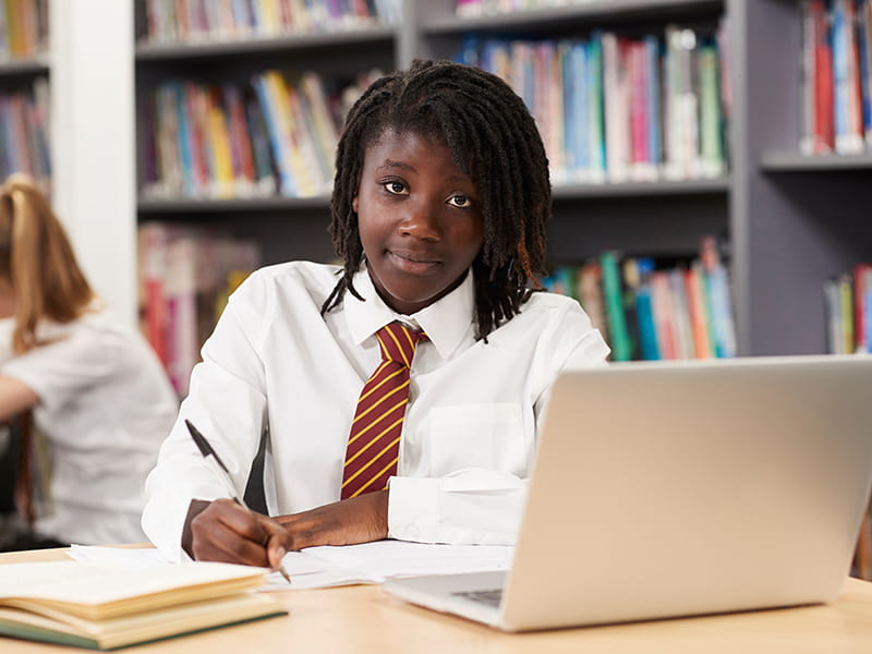 An African girl student studying in a school library
