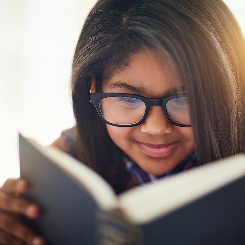 Young girl reading a book to learn English